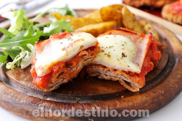 La milanesa napolitana o milanesa a la napolitana es un plato que consiste en una milanesa, generalmente de carna vacuna al horno, y recubierta de manera similar a una pizza, cuyo origen se encuentra en Buenos Aires. (Foto: Cocina Total).